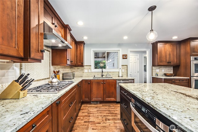 15068 NE 13th St, Bellevue, WA 98007 - kitchen featuring under cabinet range hood, appliances with stainless steel finishes, wood finished floors, light stone counters, and recessed lighting