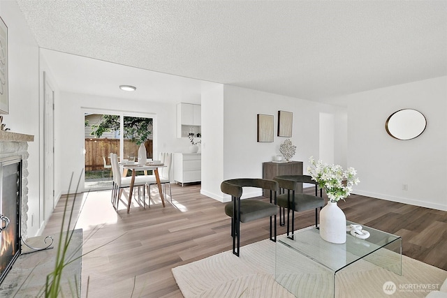 25035 34th Ave S, Kent, WA 98032 - living area featuring wood finished floors, a stone fireplace, and a textured ceiling