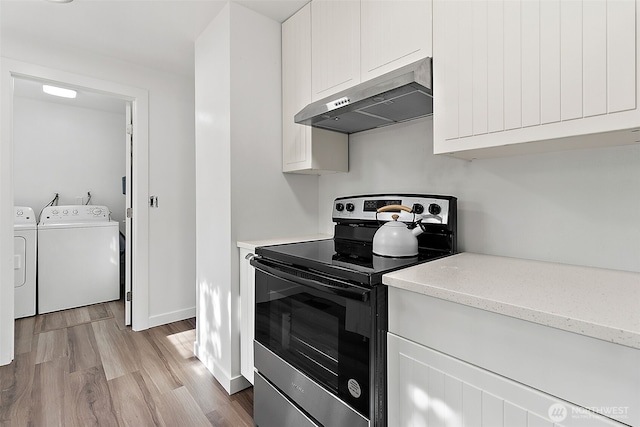 25035 34th Ave S, Kent, WA 98032 - kitchen featuring stainless steel electric range oven, extractor fan, washing machine and clothes dryer, light wood-style floors, and white cabinets