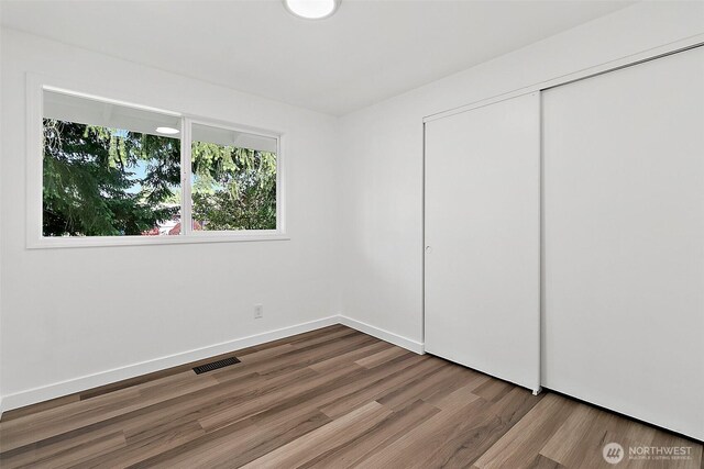 25035 34th Ave S, Kent, WA 98032 - unfurnished bedroom featuring wood finished floors and a closet