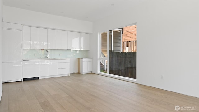 1114 26th Ave Unit B, Seattle, WA 98122 - kitchen featuring white dishwasher, light wood-type flooring, white cabinetry, and modern cabinets