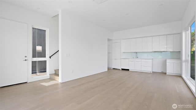 1114 26th Ave Unit B, Seattle, WA 98122 - unfurnished living room featuring light wood-style flooring and stairway