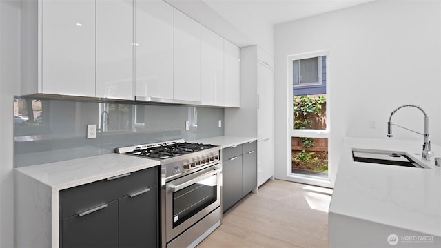1112 26th Ave Unit A, Seattle, WA 98122 - kitchen featuring gas stove, a sink, modern cabinets, and light wood finished floors