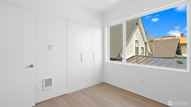 1112 26th Ave Unit A, Seattle, WA 98122 - unfurnished bedroom with wood finished floors, a closet, and heating unit