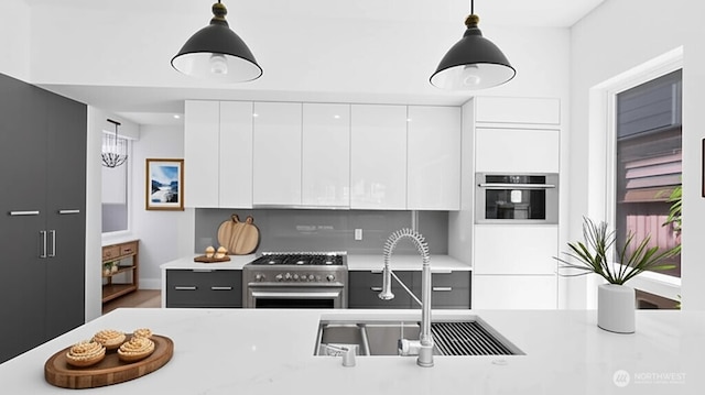 1112 26th Ave Unit A, Seattle, WA 98122 - kitchen featuring appliances with stainless steel finishes, modern cabinets, light countertops, white cabinetry, and pendant lighting