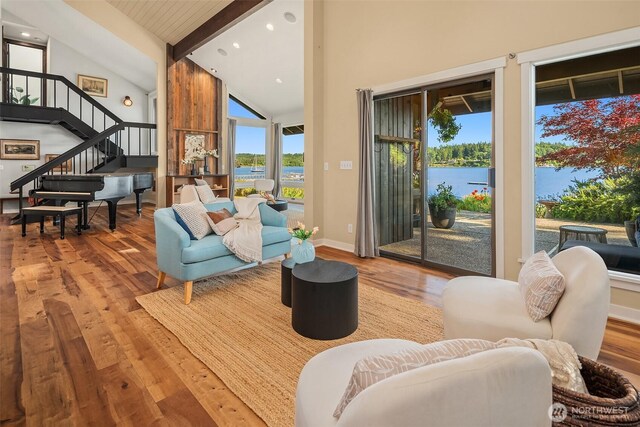 9707 SW Quartermaster Dr, Vashon, WA 98070 - living room featuring high vaulted ceiling, beam ceiling, wood finished floors, stairs, and a water view