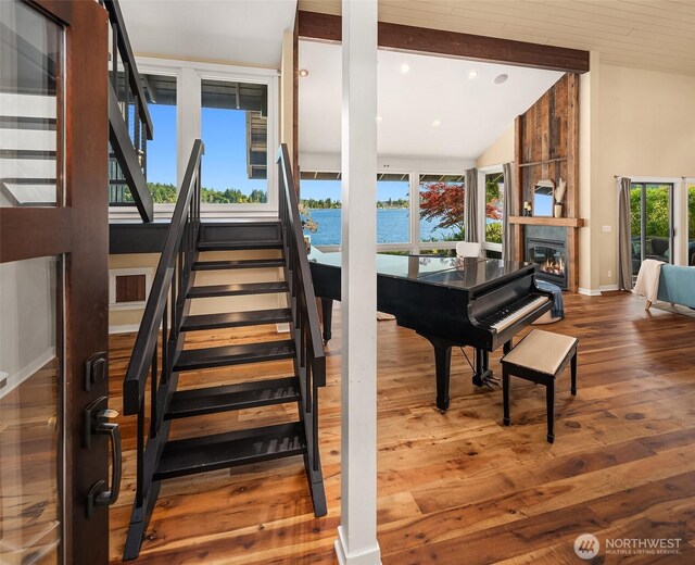 9707 SW Quartermaster Dr, Vashon, WA 98070 - stairs with wood finished floors, lofted ceiling, a fireplace, a water view, and recessed lighting
