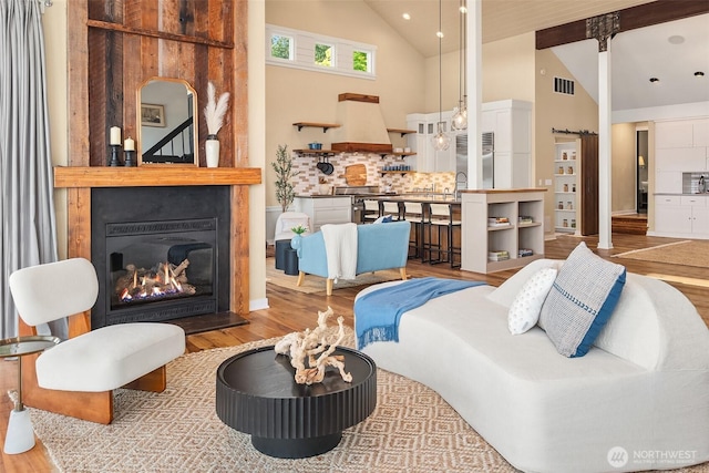 9707 SW Quartermaster Dr, Vashon, WA 98070 - living area featuring wood finished floors, high vaulted ceiling, and a large fireplace