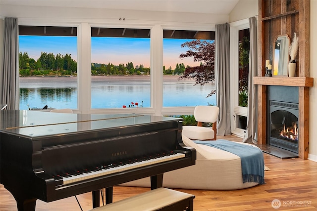 9707 SW Quartermaster Dr, Vashon, WA 98070 - sitting room featuring a water view, wood finished floors, lofted ceiling, and a large fireplace