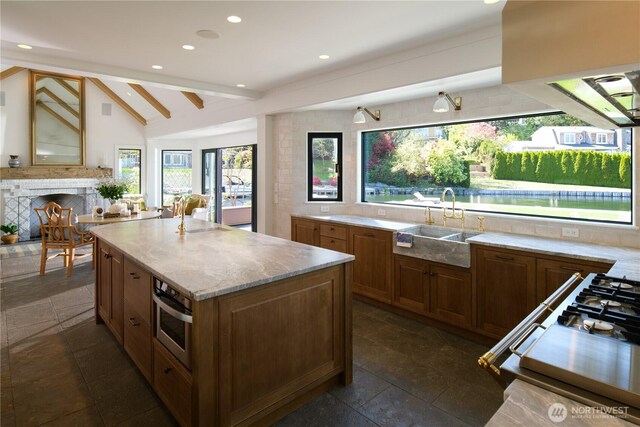 8580 Hunts Point Ln, Hunts Point, WA 98004 - kitchen featuring oven, a sink, a fireplace, a center island, and light stone countertops