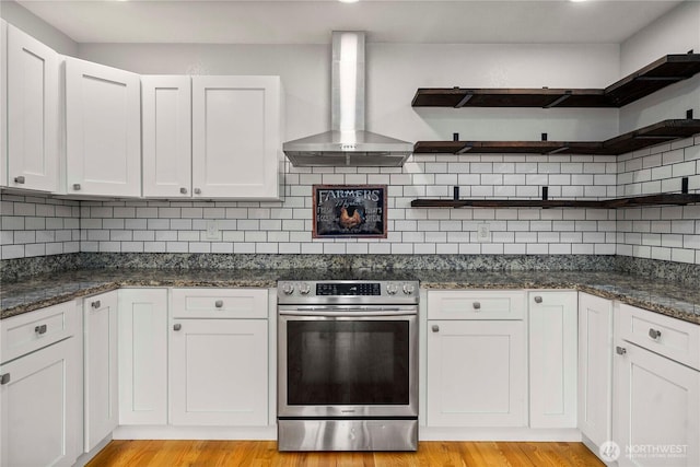 113 W Chenault Ave, Hoquiam, WA 98550 - kitchen with open shelves, stainless steel electric range oven, wall chimney exhaust hood, dark stone counters, and light wood finished floors