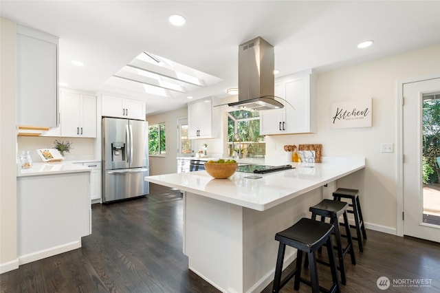 604 N 178th St, Shoreline, WA 98133 - kitchen with stainless steel fridge, island exhaust hood, a peninsula, a kitchen breakfast bar, and white cabinetry