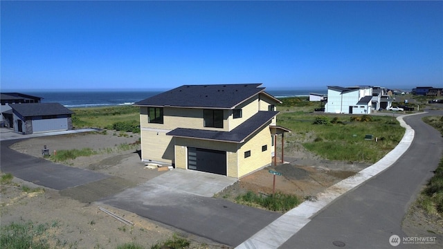 1421 S Cohasset Crst, Westport, WA 98595 - view of property exterior with concrete driveway, a water view, and an attached garage