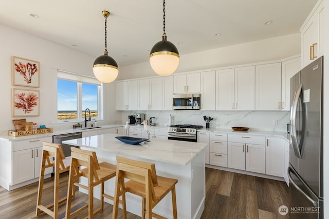 1421 S Cohasset Crst, Westport, WA 98595 - kitchen with appliances with stainless steel finishes, a sink, dark wood-style flooring, white cabinetry, and light stone countertops