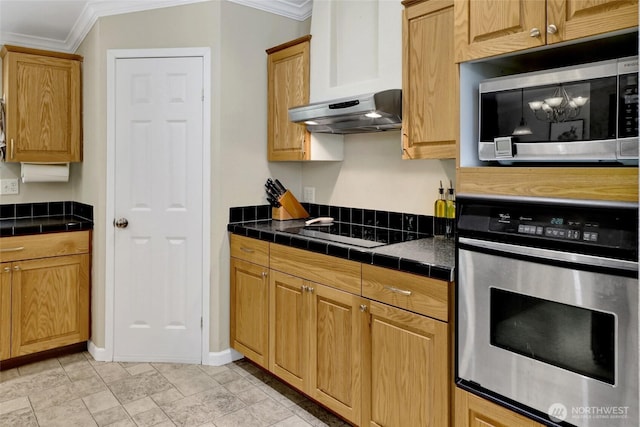 6098 Mt Baker Hwy, Deming, WA 98244 - kitchen featuring appliances with stainless steel finishes, crown molding, tile countertops, and under cabinet range hood