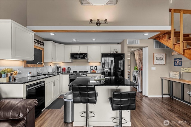 8903 Crescent Bar Rd NW Unit 18, Quincy, WA 98848 - kitchen with black appliances, a sink, dark countertops, white cabinets, and dark wood-type flooring