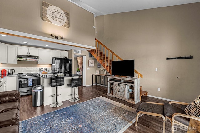 8903 Crescent Bar Rd NW Unit 18, Quincy, WA 98848 - living area with stairway, dark wood-style floors, baseboards, and a towering ceiling