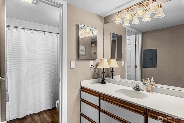 8903 Crescent Bar Rd NW Unit 18, Quincy, WA 98848 - full bathroom with toilet, electric panel, vanity, wood finished floors, and shower / bathtub combination with curtain