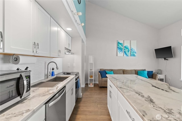 8903 Crescent Bar Rd Unit 158, Quincy, WA 98848 - kitchen featuring appliances with stainless steel finishes, a sink, wood finished floors, tasteful backsplash, and white cabinetry