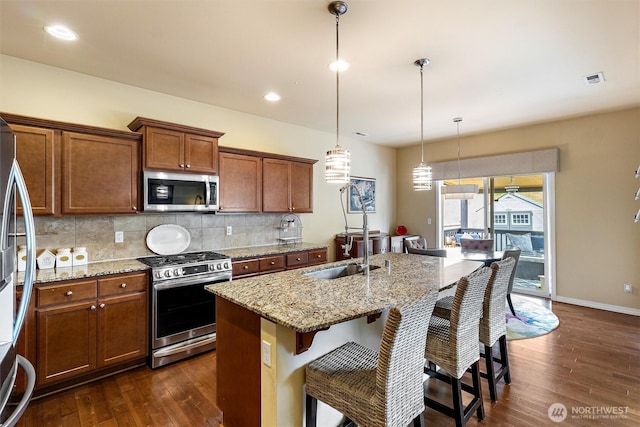 5418 Bennett Ave SE, Auburn, WA 98092 - kitchen featuring stainless steel appliances, a sink, brown cabinets, dark wood-type flooring, and recessed lighting