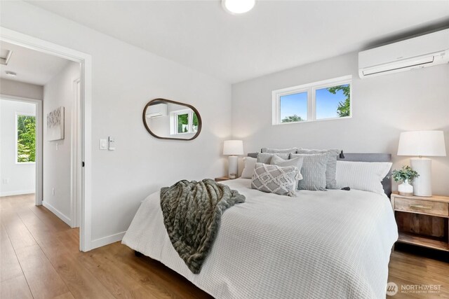 6014 40th Ave NE Unit B, Seattle, WA 98115 - bedroom with a wall mounted air conditioner, baseboards, and wood finished floors