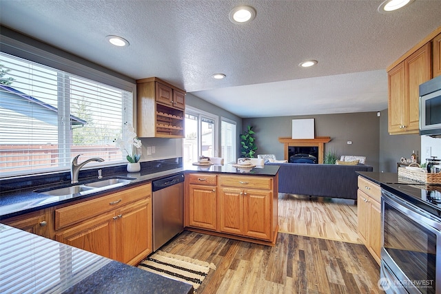 109 77th Pl SW, Everett, WA 98203 - kitchen with stainless steel appliances, a sink, a textured ceiling, wood finished floors, and dark countertops