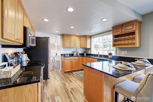 109 77th Pl SW, Everett, WA 98203 - kitchen with a peninsula, a sink, a kitchen bar, light wood-type flooring, and recessed lighting
