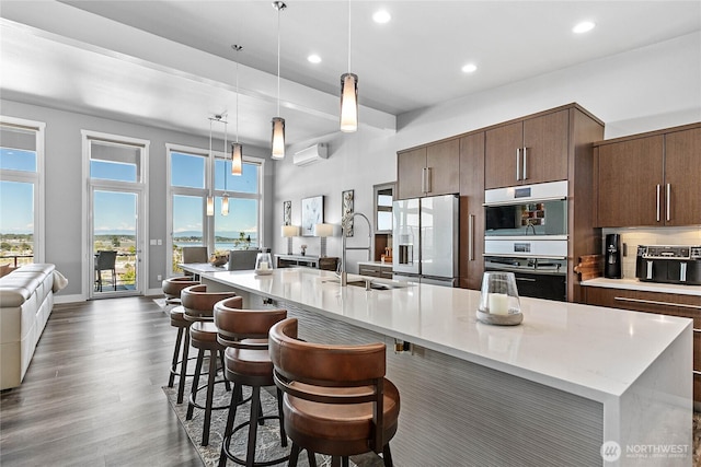 8054 Makah Rd, Birch Bay, WA 98230 - kitchen featuring stainless steel fridge, light countertops, recessed lighting, a breakfast bar, and open floor plan