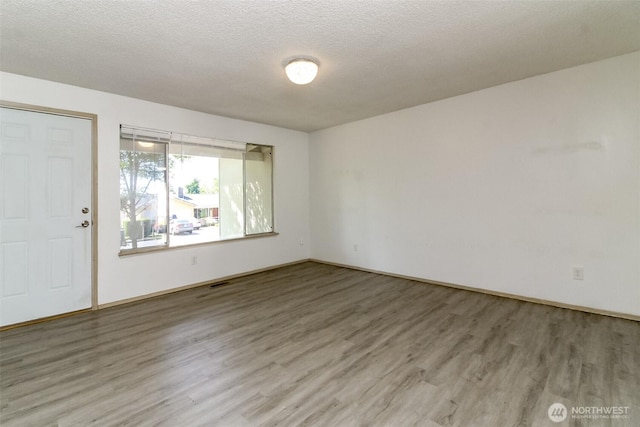 28312 22nd Ave S, Federal Way, WA 98003 - unfurnished room with wood finished floors, a textured ceiling, and baseboards