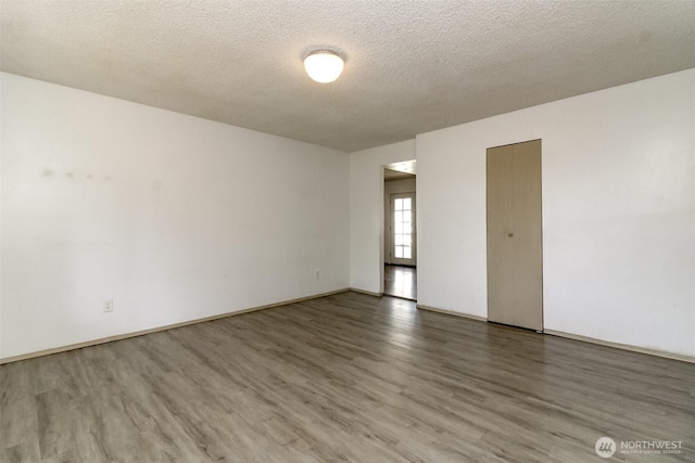 28312 22nd Ave S, Federal Way, WA 98003 - spare room featuring wood finished floors, a textured ceiling, and baseboards