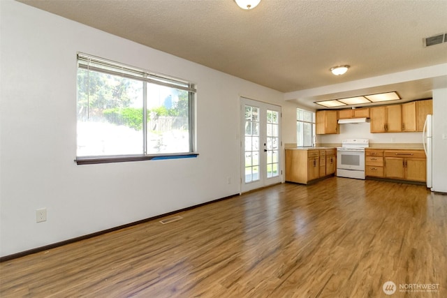 28312 22nd Ave S, Federal Way, WA 98003 - kitchen with white appliances, wood finished floors, light countertops, under cabinet range hood, and a textured ceiling