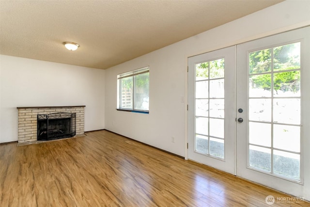 28312 22nd Ave S, Federal Way, WA 98003 - unfurnished living room with wood finished floors, a fireplace, and french doors