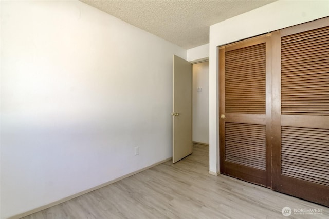 28312 22nd Ave S, Federal Way, WA 98003 - unfurnished bedroom featuring wood finished floors, a closet, a textured ceiling, and baseboards