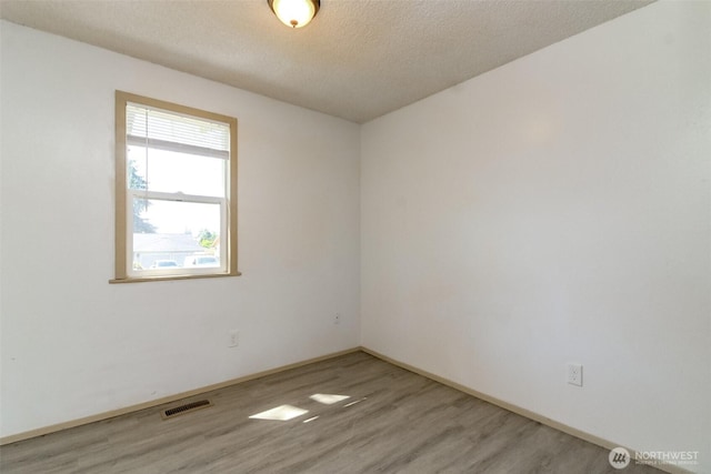 28312 22nd Ave S, Federal Way, WA 98003 - spare room featuring light wood-style floors, a textured ceiling, and baseboards