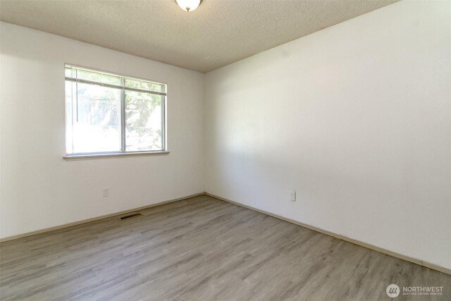 28312 22nd Ave S, Federal Way, WA 98003 - empty room with wood finished floors and a textured ceiling