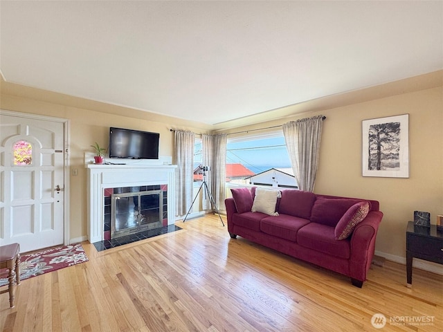 13151/2 W 5th St, Port Angeles, WA 98363 - living room featuring wood finished floors, a tiled fireplace, and baseboards