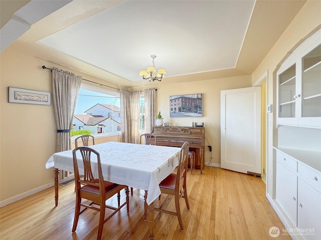 13151/2 W 5th St, Port Angeles, WA 98363 - dining room with a chandelier, light wood-style flooring, baseboards, and a tray ceiling