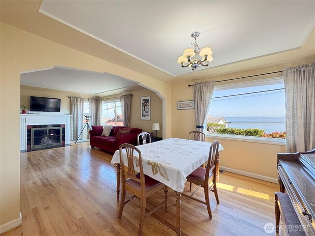 13151/2 W 5th St, Port Angeles, WA 98363 - dining area with a chandelier, light wood finished floors, baseboards, and arched walkways