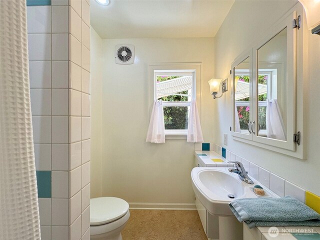 13151/2 W 5th St, Port Angeles, WA 98363 - bathroom featuring toilet, baseboards, a shower with shower curtain, and a sink