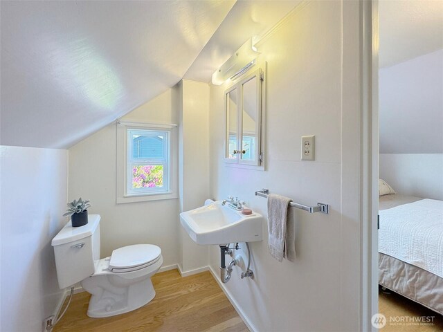 13151/2 W 5th St, Port Angeles, WA 98363 - half bath with wood finished floors, toilet, lofted ceiling, connected bathroom, and a sink