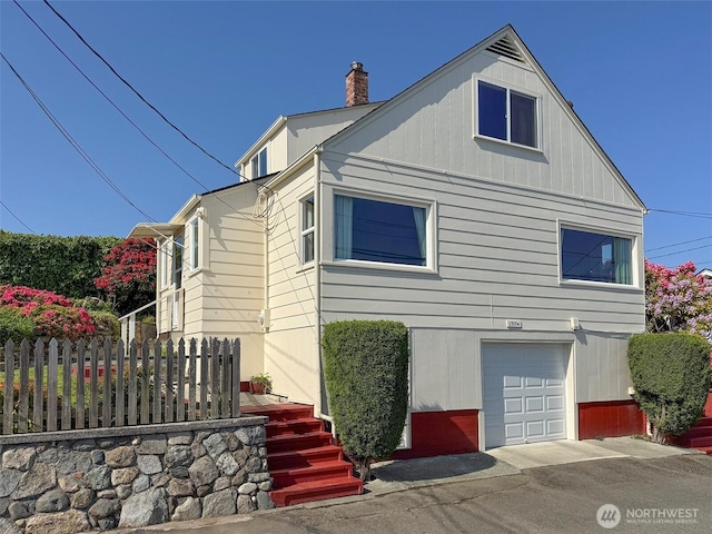 13151/2 W 5th St, Port Angeles, WA 98363 - view of home's exterior featuring a chimney and an attached garage