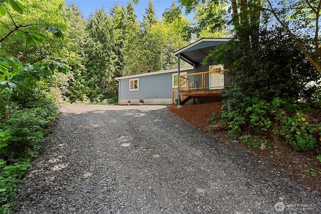 29722 State Highway 3 NE, Poulsbo, WA 98370 - view of property exterior with a wooden deck, gravel driveway, and crawl space
