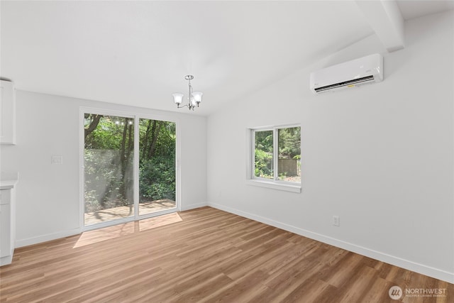 29722 State Highway 3 NE, Poulsbo, WA 98370 - unfurnished room with a wall mounted AC, healthy amount of natural light, vaulted ceiling, a chandelier, and baseboards