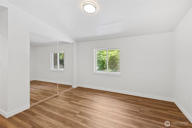 29722 State Highway 3 NE, Poulsbo, WA 98370 - unfurnished bedroom featuring baseboards, a closet, wood finished floors, and lofted ceiling