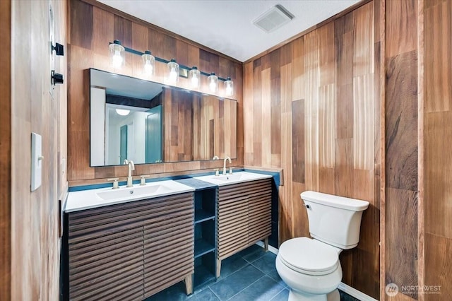 12712 NE 120th St Unit G1, Kirkland, WA 98034 - bathroom with double vanity, toilet, wooden walls, and tile patterned floors