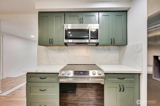 12712 NE 120th St Unit G1, Kirkland, WA 98034 - kitchen with green cabinetry, appliances with stainless steel finishes, and backsplash