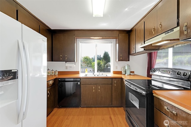 10610-10608 109th St SW, Lakewood, WA 98498 - kitchen featuring black appliances, under cabinet range hood, a sink, light wood-type flooring, and light countertops