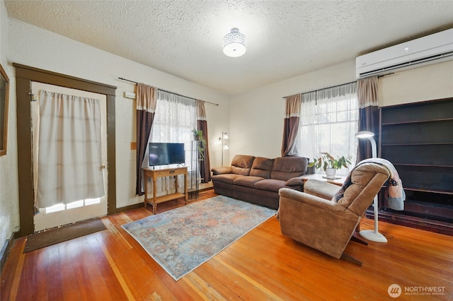507 S 3rd St, Dayton, WA 99328 - living room with an AC wall unit, a textured ceiling, and hardwood / wood-style flooring
