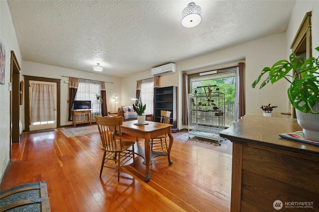 507 S 3rd St, Dayton, WA 99328 - dining room featuring a wall mounted AC, a textured ceiling, and light wood-style flooring