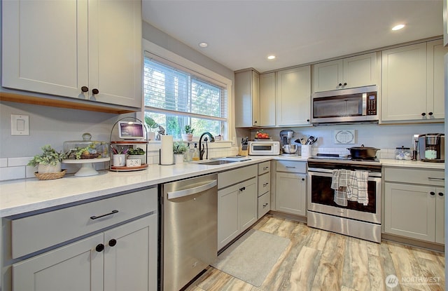 10012 NE 39th St, Vancouver, WA 98662 - kitchen with stainless steel appliances, a sink, light wood-style flooring, gray cabinets, and recessed lighting